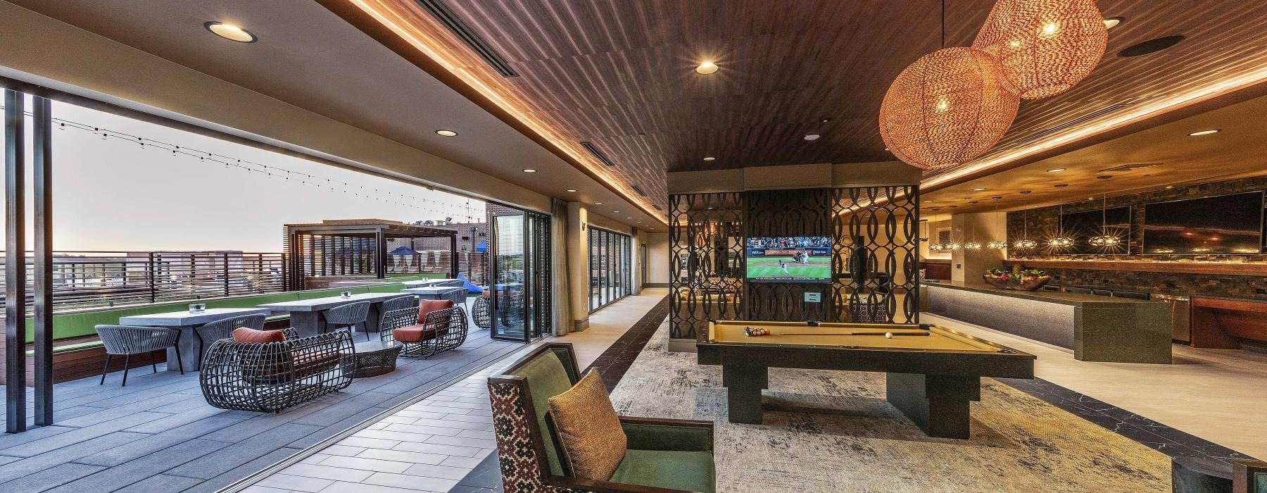 a room with a pool table tv and chairs